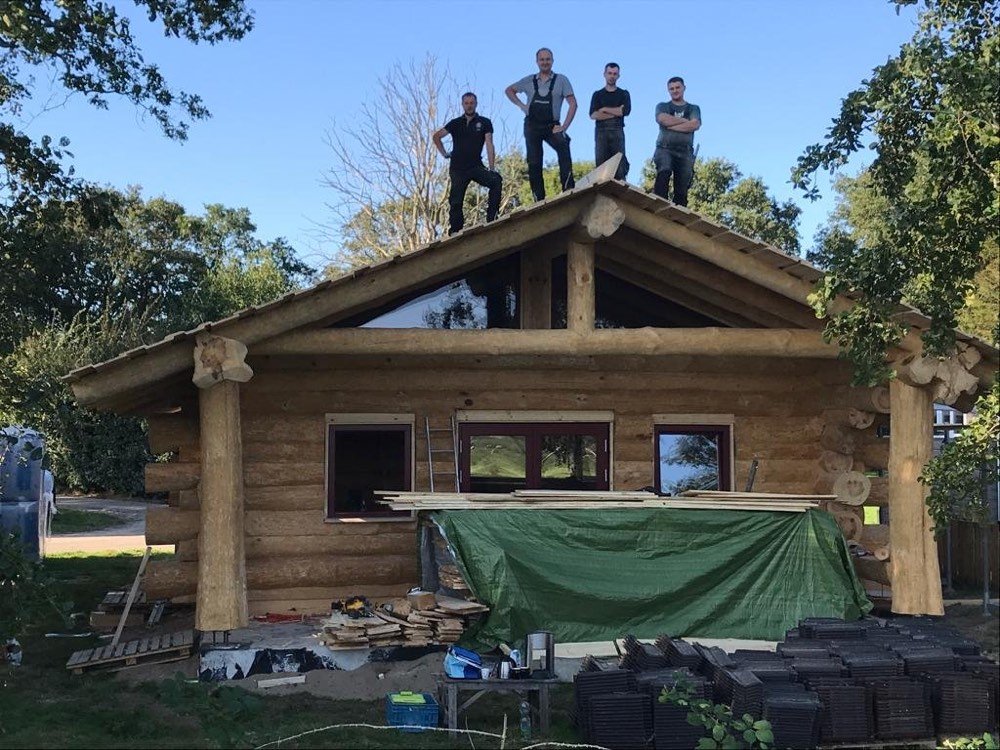 Bouwers op het dak van het boomstamhuis in Den Oever