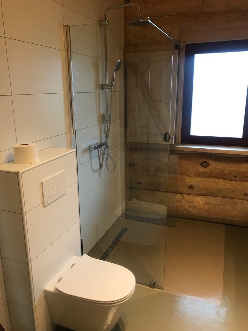 Inloopdouche naast de wand van boomstammen